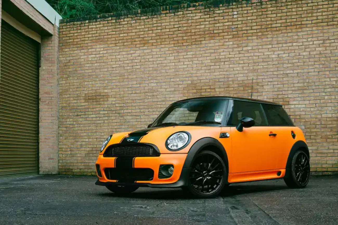 Three-quarter view of Mini Cooper John Cooper Works with matte orange colour change wrap at Wrap Your Car Kidderminster