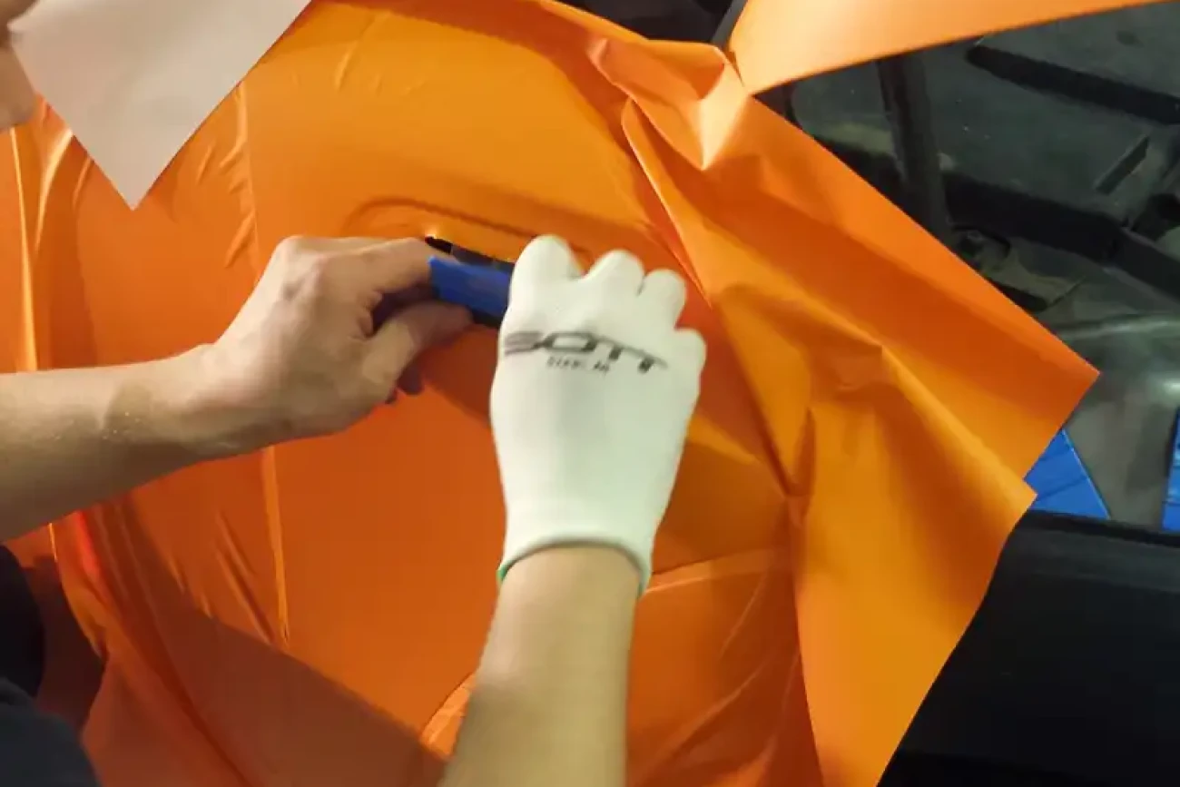 Matte orange colour change wrap being heat-formed and applied during installation on a Mini JCW at Wrap Your Car Kidderminster
